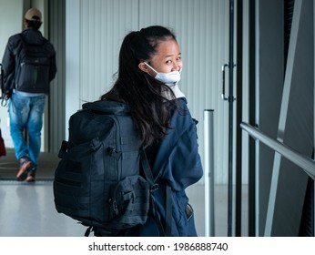 Medellin, Antioquia, Colombia - May 17 2021: Small Asian Woman With Mask Walks  Down Aisle With Backpack To Board Plane 