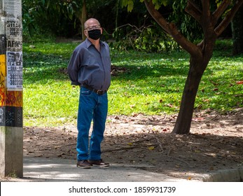 Medellin, Antioquia / Colombia - November 15 2020: Older Man Wearing Glasses And A Black Face Mask Is Standing Looking At The Camera