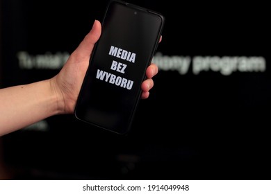 Media Blackout Protest In Poland. A Person Is Holding A Smartphone With The Sign “Media Bez Wyboru” (Eng. Media Without A Choice) In Front Of A Black TV Screen.