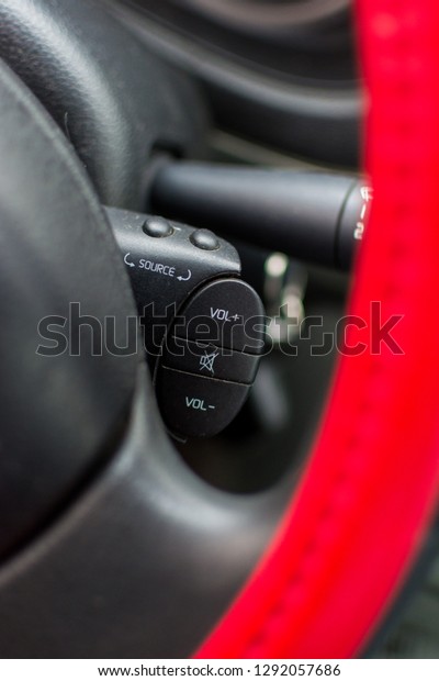 Media\
control buttons behind a cars steering\
wheel