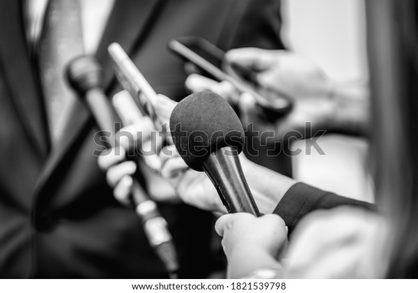 Media Interview -\
journalists with microphones interviewing formal dressed politician\
or businessman.