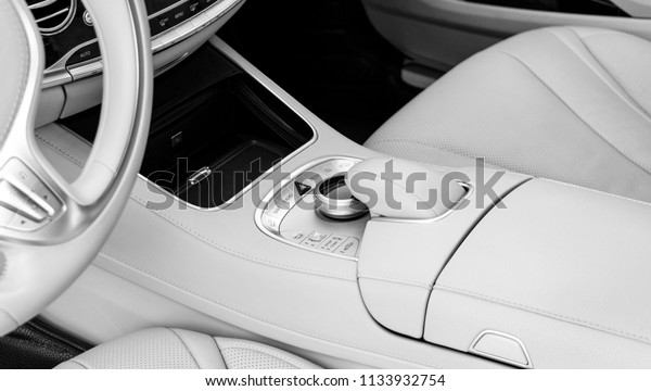 Media and navigation control
buttons. Car interior details. White leather interior of the luxury
modern car. Modern car interior. Car detailing. Black and
white