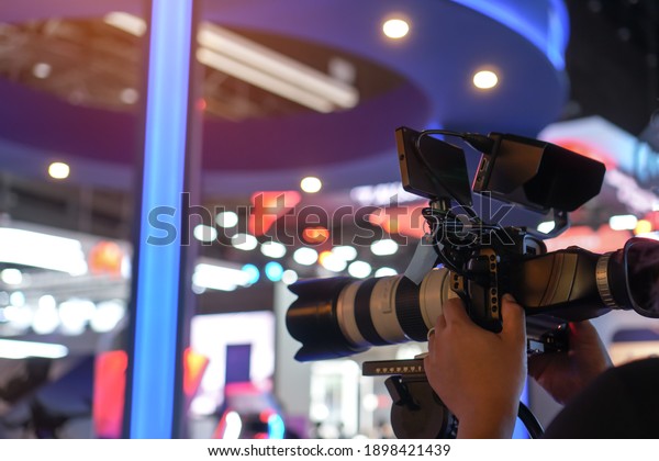 Media Television film Production and\
interview reporter concept: Video recorder movie recording films\
shooting of grand opening in conference hall live event streaming\
for presentation by\
videographer