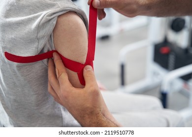 Medic Putting Fabric Self Adhesive Bandage On Arm