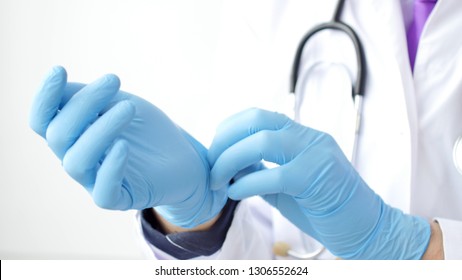 Medica doctor puting on blue latex gloves, closeup