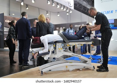 MEDICA Trade Fair, DUSSELDORF, GERMANY - NOVEMBER 2019, Manual Therapy, An Instructor Treats The Back Of A Woman On A Couch.