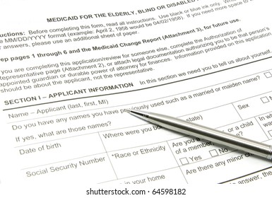A Medicaid Application Ready To Be Filled Out With A Silver Pen.