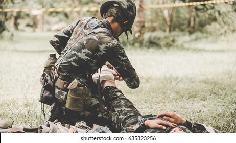 medical aid symbol on a vintage jute army bag , military explain technique use tourniquet stop bleed arm