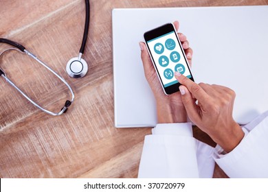 Medical App Against Doctor Using Smartphone On Wooden Desk