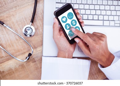 Medical App Against Doctor Using Smartphone On Wooden Desk