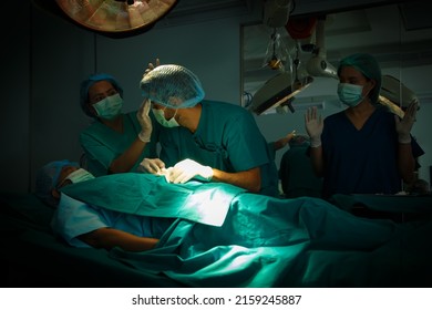 Medical Assistant Was Wiping The Sweat For The Young Doctor, Young Surgeon Man And The Medical Team Is Operating On An Elderly Patient In Hospital, Medical And Healthy Concept, Copy Space