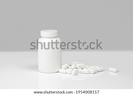 Medical background of many white capsule tablets or pills on the table. Mock up container. Healthcare pharmacy and medicine concept with copy space Painkillers or prescription drugs consumption