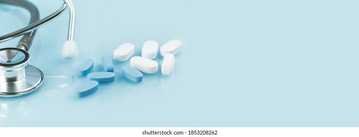 Medical background. white and blue capsule tablets or pills on the table with stethoscope. Close up. Healthcare pharmacy and medicine concept. Painkillers or prescription drugs consumption banner - Shutterstock ID 1853208262