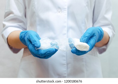 Medical bandage in the doctor hands dressed in the blue medical gown. - Shutterstock ID 1200180676