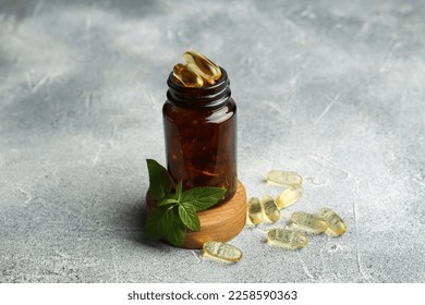 Medical bottle, mint and yellow capsules on light gray textured table - Powered by Shutterstock