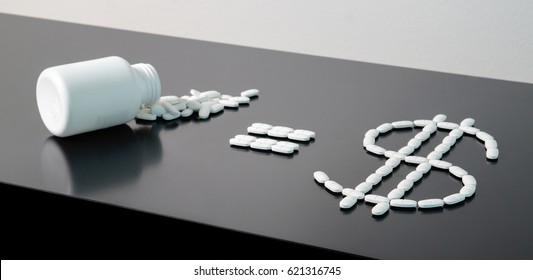 Medical Business Or Prices Concept. Making Money In Pharmaceutical Industry Or High Medical Expenses. Medicine Spilling Out Of A Package On Table. Pill Bottle Equals Dollar Sign Written With Pills. 