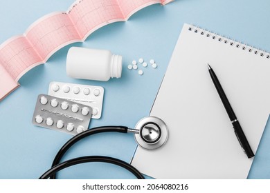 medical card and medicaments on blue background. Cardiovascular disease treatment plan. Blisters of medical pills. Top view pharmacy drug. Healthcare concept. List of treatments. Heart health, tablets