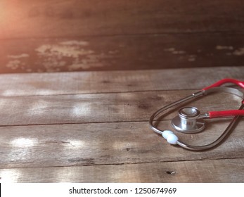 Medical Cardiologist,Stethoscope, On Old Wood,dark Tone,with Copy Space. Selective Focus, Rural Style, With Lens Flare. Health Care And Medical Concept.