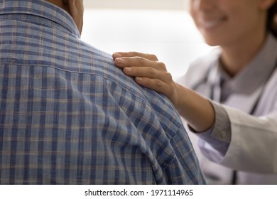 Medical care. Close up of smiling confident young female doctor putting hand on male patient shoulder. Caring clinic worker comfort anxious sick man inspire optimism belief in good result of therapy - Shutterstock ID 1971114965