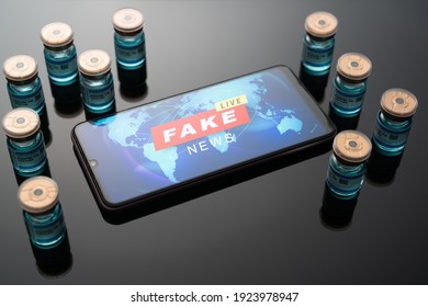 Medical Concept Ampoules Or Vials With Covid-19 Vaccine On A Laboratory Bench With A Smartphone Display Fake News Message