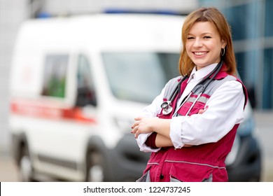 Medical Concept. Happy Paramedic Female With Phonendoscope At Emergency Car Background