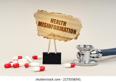 Medical concept. Near the stethoscope are pills and a clip with a cardboard sign - health misinformation
