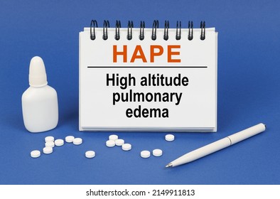 Medical Concept. On A Blue Background, A Pen, Tablets And A Notepad With The Inscription - HAPE High Altitude Pulmonary Edema