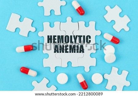 Medical concept. On a blue background, pills, capsules and puzzles with the inscription - Hemolytic anemia
