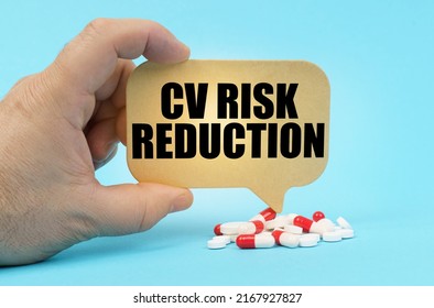 Medical Concept. On A Blue Surface Are Pills In A Persons Hand, A Sign With The Inscription - CV Risk Reduction