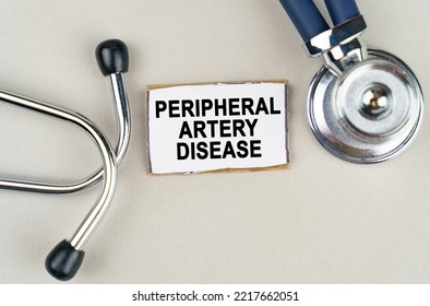 Medical concept. On a gray background, a stethoscope and a cardboard sign with the inscription - Peripheral artery disease