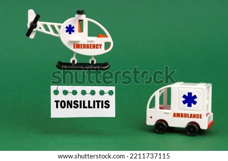Medical concept. On a green surface, an ambulance car and a helicopter with a sign - Tonsillitis