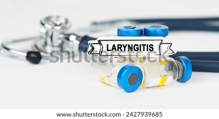 Medical concept. On the table there is a stethoscope, injections and a sign with the inscription - Laryngitis