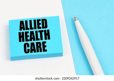 Medical Concept. On A White And Blue Surface, A Pen And Blue Stickers With The Inscription - Allied Health Care