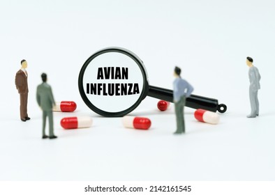 Medical concept. On a white surface are pills, figurines of people and a magnifying glass with the inscription - Avian Influenza