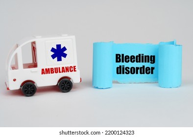 Medical Concept. On A White Surface, An Ambulance And A Blue Paper Sign With The Inscription - Bleeding Disorder