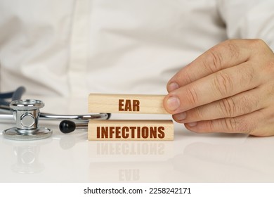 Medical concept. On a white surface, a stethoscope and wooden plates with the inscription - ear infections - Shutterstock ID 2258242171