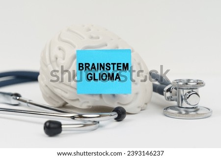 Medical concept. On a white surface next to the stethoscope lies a brain on which a sticker with the inscription - Brainstem glioma