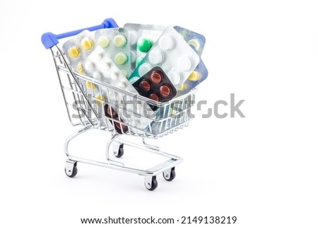 Medical concept of shopping cart fully filled with packaged pills isolated on white background. Various pills in blister packages. Ideas for healthcare, shopping in pharmacies