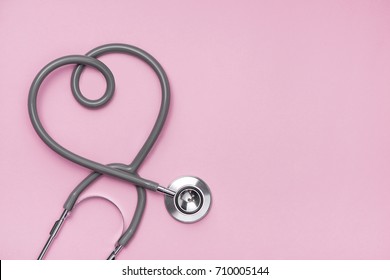 Medical concept. The stethoscope with heart shape on pink background.
