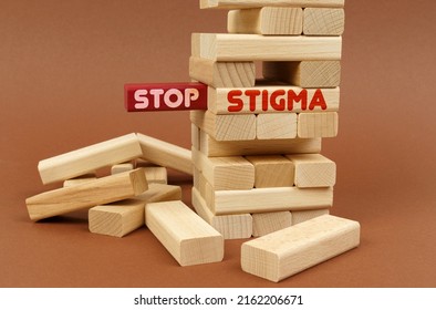 Medical concept. There is a wooden tower on a brown surface. On the red block there is an inscription - Stop, on the next block - Stigma