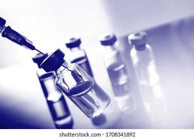Medical concept Vaccination vaccine vial dose flu shot drug needle syringe. Blue color filter