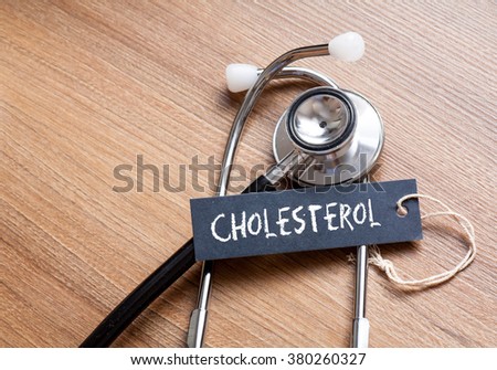 Medical Concept-Cholesterol word written on label tag with Stethoscope on wood background