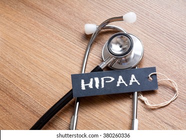 Medical Concept-HIPAA word written on label tag with Stethoscope on wood background