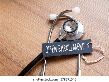 Medical Concept-Open Enrollment written on label tag with Stethoscope on wood background