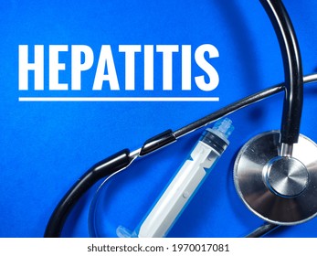 Medical Concept.Text HEPATITIS With Syringe And Stethoscope On Blue Background.