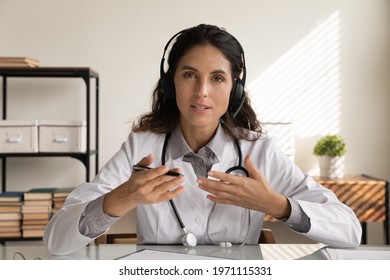 Medical Conference. Latin Female Doctor Surgeon Therapist In Headset Look At Camera Talk Share Experience With Colleagues At Online Event. Portrait Of Female Gp Speaking Helping Patient By Videocall