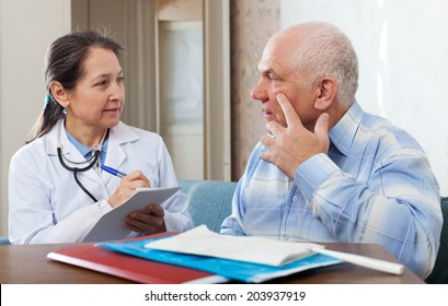 Medical Consultation. Senior Patient And Doctor Talking At Table