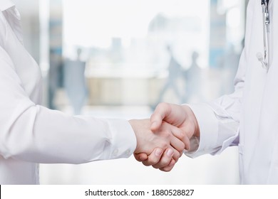 Medical Cooperation Concept. Doctors Handshake On Blurred Hospital Background.