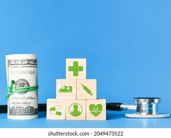 Medical Cost And Insurance Concept. Wooden Cubes With Medical Icons, Fake Money Ans Stethescope.