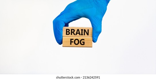 Medical And COVID-19 Pandemic Brain Fog Symbol. Doctor Hand In Blue Glove Holds Wooden Blocks With Words 'brain Fog'. Beautiful White Background. Copy Space. Medical And Covid-19 Brain Fog Concept.